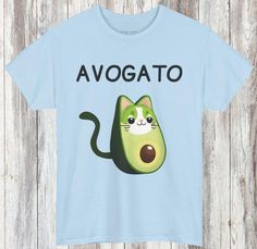 Avogato T Shirt - Custom T Shirt Meet your new favorite shirt - the personalized Avogato T-Shirt! This adorable design features an avocado with a cute cat face, playfully labeled "Avogato." Perfect for avocado and cat lovers alike, this custom t-shirt can be personalized with your cat pet name, your name or a loved one's name, making it a one-of-a-kind piece. This avocado cat t-shirt is made from soft, comfortable fabric, making it ideal for everyday wear. Whether you're a fan of kawaii avocado designs or simply love a fantastic avocado tee, this shirt is sure to bring a smile to your face. Key Features: Charming avogato design (avocado with a cat face) Personalize with your name or a loved one's name Available in multiple sizes and colors Made from soft, comfortable fabric Perfect for cas Kawaii Avocado, Gym T Shirts, Avocado Design, Avocado Shirt, Avocado T Shirt, Cute Cat Face, Cute Avocado, A Cute Cat, Pet Name