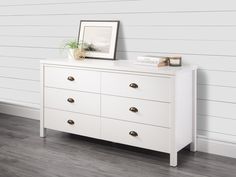 a white dresser with a plant on top