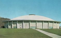 a large white building sitting on top of a lush green field