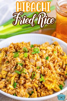 a white bowl filled with fried rice next to a jar of honey and celery