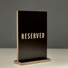 a black and gold book with the word reserved on it sitting on a white surface