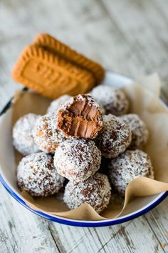 a bowl filled with chocolate covered donuts next to a peanut butter baguette