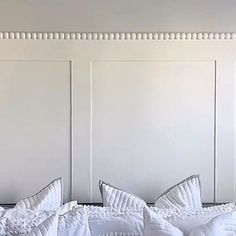 a white bed topped with lots of pillows