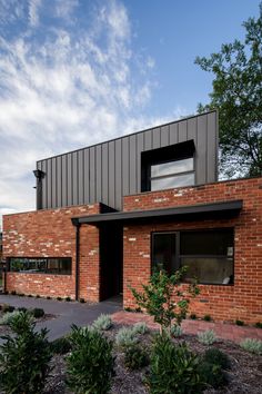 a red brick building with trees and bushes around it