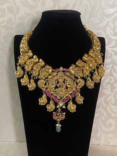 Antique Lakshmi Pendent Temple Necklace An antique Lakshmi temple necklace is a traditional piece of South Indian jewelry, often crafted in gold or gold-plated metal. The necklace typically features intricate designs inspired by temple architecture and Hindu mythology, particularly the goddess Lakshmi, who symbolizes wealth and prosperity. Luxury Handmade Elegant Temple Necklace, Traditional Brass Temple Necklace, Luxury, Luxury Formal Temple Necklace With Tilla Details, Luxury Engraved Temple Necklace For Ceremonial Occasions, Luxury Wedding Temple Necklace With Intricate Design, Luxury Heavy Temple Necklace For Puja, Luxury Traditional Gemstone Temple Necklace, Luxury Traditional Beaded Temple Necklace, Luxury Ceremonial Temple Necklace For Diwali