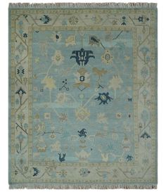 a blue and beige rug with various designs on the border, including flowers and birds