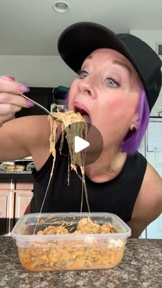 a woman eating spaghetti from a plastic container