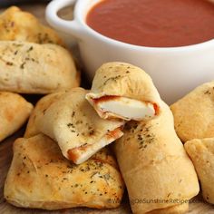 several pastries are stacked on top of each other with dipping sauce in the background