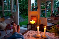 a person sitting in front of a fire place with two candles on top of it