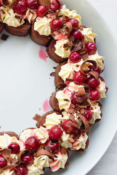 a white plate topped with cakes covered in frosting and cranberry toppings