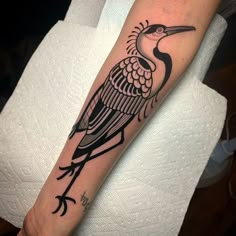 a black and white bird tattoo on the arm