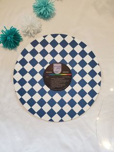 a blue and white checkerboard plate on a table with pom poms