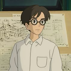 a man with glasses standing in front of a drawing