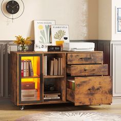 a wooden cabinet with drawers and books on it in a living room next to a clock