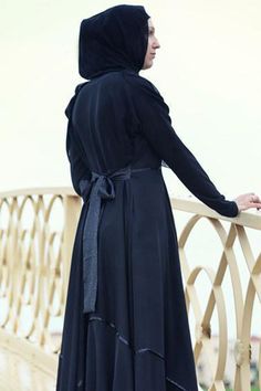 Experience a touch of sophistication with our specially designed abaya featuring a full circle skirt made from premium black Nahda fabric. The abaya boasts a high collar with three hidden clasps and a decorative trim that highlights two elegant shades of black. The included belt allows for adjustable fit, ensuring comfort and style. Please note that the white flowers visible in the images are part of the brand watermark and not the actual design. The trimming and belt design may vary slightly bu Full Circle Skirt, Belt Design, Abaya Dress, Full Circle Skirts, Decorative Trim, Full Circle, Adjustable Belt, Circle Skirt, Shades Of Black