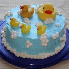 a blue cake with rubber ducks on it