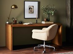 a desk with a chair next to it and a framed photo on the wall behind it