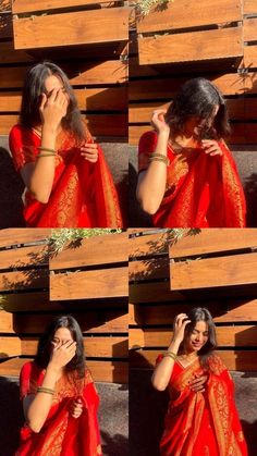 a woman in red sari covering her face and talking on the phone while standing next to wooden pallets