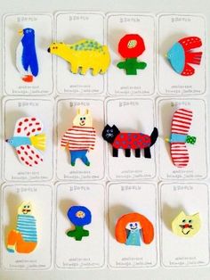 an assortment of wooden pins with animals on them in various colors and sizes, including blue, red, yellow, green, orange