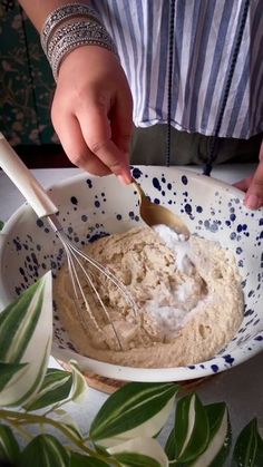 a person mixing something in a bowl with a whisk