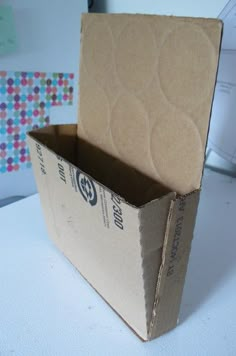 an open cardboard box sitting on top of a white table next to a computer keyboard