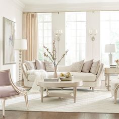 a living room filled with white furniture and lots of window sill space in front of the windows