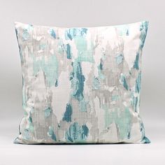 a blue and white pillow on a gray background