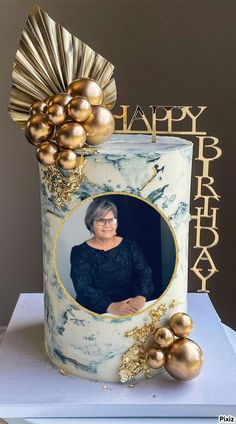 a birthday cake with an image of a woman in the center and gold ornaments around it