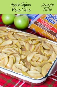 an apple spice poke cake in a baking dish with apples and yogurt behind it