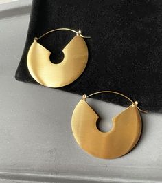 A brushed texture arc style earrings that feature 14k gold plated titanium and a brushed/matte finish Modern Semi-circle Earrings For Everyday, Matte Gold Round Tarnish Resistant Earrings, Modern Matte Gold Earrings, Contemporary Gold Metal Earrings, Modern Semi-circle Earrings For Everyday Wear, Modern Matte Gold Earrings For Gift, Modern Gold Jewelry With Matte Finish, Modern Matte Finish Gold Jewelry, Matte Gold Brass Hoop Earrings