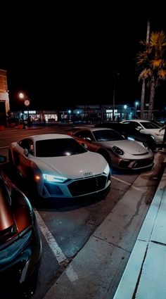 several cars parked in a parking lot at night