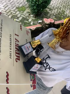 a woman standing next to a table with trophies on it