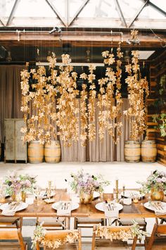 a table set up with flowers hanging from the ceiling