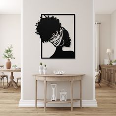 a black and white silhouette of a woman's head on a wall above a table