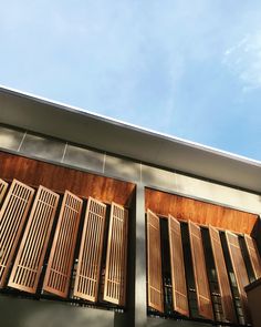 wooden shutters on the side of a building with blue sky in the back ground