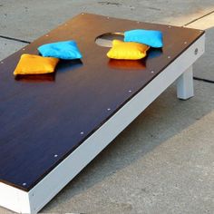 two blue and yellow pillows are on top of a white table with holes in it