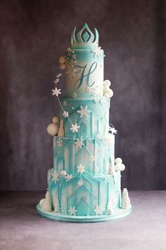 a three tiered cake decorated with frosting and snowflakes