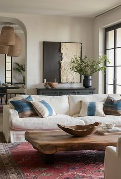 a living room filled with lots of furniture and decor on top of a rug covered floor