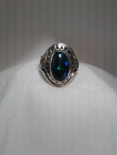 Beautiful blackl opal (3/8 x 5/8) 9 x 16mm with patterned sterling silver band and decorative bezel.  Made with Sterling, Fine silver and Argentium silver. Lots of green and blue flash in opal.  Terrific  gift for the October birthday or Christmas gift. This is a one of a kind ring so only available in size 7 1/2. I have other black opals but they are not as large as this one.  If you are interested in having a ring made with a smaller black opal, contact me. Polished Opal Ring In Oval Cabochon Shape, Opal Oval Cabochon Ring With Polished Finish, Polished Opal Oval Cabochon Ring, Formal Sterling Silver Opal Ring Oval Cabochon, Formal Sterling Silver Opal Ring With Oval Cabochon, Oval Opal Rings With Polished Finish, Sterling Silver Oval Opal Cabochon Ring, Oval Cabochon Opal Ring In Sterling Silver, Black Oval Opal Ring For Formal Occasions