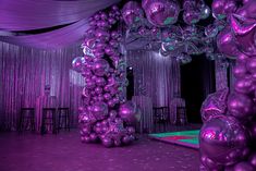 an elaborately decorated stage with purple balloons