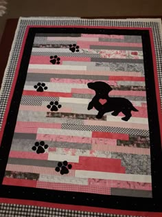 a quilt made to look like a dog with paw prints on it and a pink border