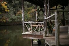 a wooden dock sitting on top of a lake next to a forest filled with trees