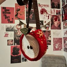 a handbag hanging from a rope with pictures on the wall behind it