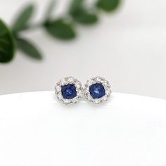 These beautiful stud earrings feature a pair of 0.30 carat wight Blue Sapphire gemstones with a halo of natural earth mined diamonds set in solid 14K gold. These Blue Sapphire studs make a lovely September birthstone gift for your loved ones! These earrings are made with solid 14k Gold and natural earth mined SI / G-H Diamonds. As listed, these earrings are ready to ship. If you're interested in purchasing this setting with a different center stone please message us! White Gold Round Gemstone Cluster Earrings, Cluster Diamond Earrings With Halo Setting Gift, Sapphire Round Cut Earrings With Halo Setting, Sapphire Halo Setting Round Cut Earrings, Sapphire Earrings With Halo Setting, Sapphire Earrings With Halo Setting For Wedding, Classic Sapphire Earrings With Halo Setting, Sapphire Halo Diamond Earrings For Weddings, Sapphire Diamond Earrings With Halo Design For Wedding