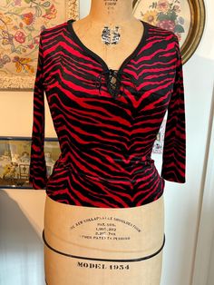 New old stock 90s funky top. Ties at chest. Tag says M but I'd say this would fit a modern 4/6.  Measurements taken with top lying flat: 16.5 inches pit to pit 12 inches across waist  20 inches top to bottom Passing through my smoke free, cat friendly home. Retro V-neck Stretch Top, Fitted V-neck Tops With Graphic Print, Fitted V-neck Top With Graphic Print, Fitted Striped Y2k Top, Striped Long Sleeve Party Top, Striped Tops For Fall Party, Casual Stretch Tiger Print Tops, Retro Fitted Black Top, Fitted Retro Black Top