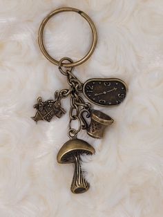 a keychain with various items attached to it on a white surface, including an umbrella and mushroom