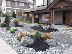 a house with rocks and plants in the front yard