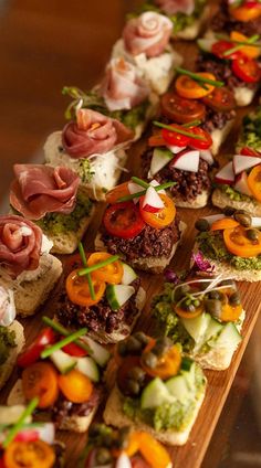 a wooden table topped with lots of different types of appetizers