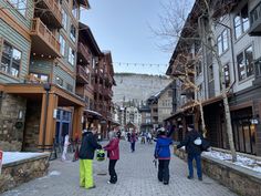 several people walking down a street lined with buildings