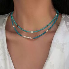 This delicate necklace brings together the serenity of turquoise beads with the subtle shimmer of moonstone. Each piece is meticulously crafted with natural freshwater pearls and blue turquoise accents, offering a unique combination of textures and colors. The adjustable chain ensures a comfortable fit, making this necklace perfect for layering or wearing on its own for a minimalist, chic look. Details Material: 24K gold-plated brass, natural freshwater pearls, turquoise, and moonstone Length: 46cm, 47cm, 46cm (with 5.5cm extension) Weight: Approx. 5.3g, 7.0g, 8.0g Style: Elegant and versatile, perfect for both casual and formal occasions Care Tips: Avoid exposure to harsh chemicals and keep dry to maintain its beauty Missy Jewelry Natural Stone Necklace Collection Turquoise Beaded Necklace, Natural Stone Necklace, Turquoise Accents, Turquoise Bead Necklaces, Pearl Jewelry Necklace, Natural Stones Necklace, Gold Statement Earrings, Necklace Collection, Natural Stone Jewelry